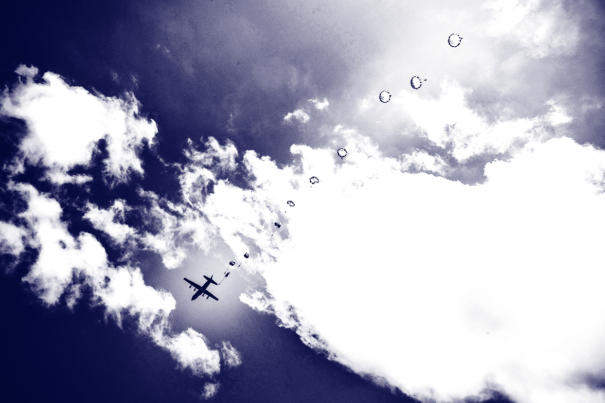 Parachuters jumping out of a plane in the sky.