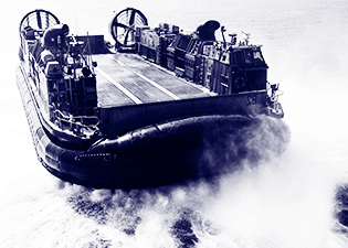 A Navy boat in clouds of sea foam.